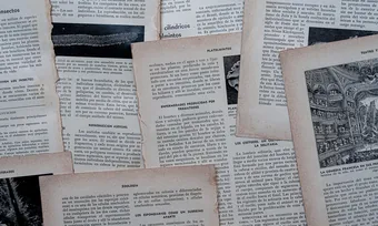 Scattered pages of old printed newspapers and documents